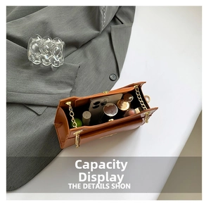 Interior view of the brown square chain bag showing capacity for phone and lipstick