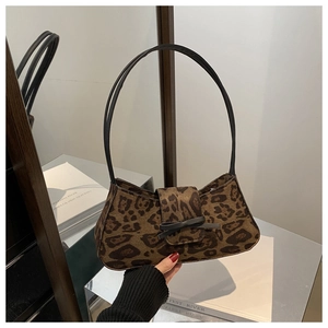 Detail shot of brown leopard print baguette bag featuring a delicate black ribbon bow