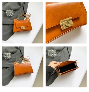 Detail view of orange chain bag with golden metal lock and interior storage space