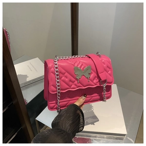 Détail du sac en similicuir rose avec fermoir papillon argenté et bandoulière
