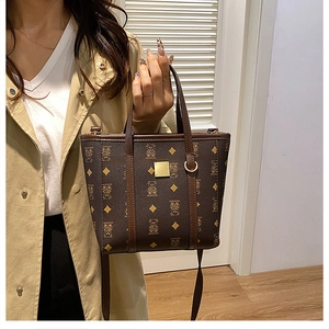 Sac seau vintage marron avec motif d'ours et monogramme porté par un mannequin