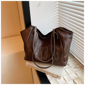 Close-up of deep brown tote bag with HNK BAG leather lettering and premium texture