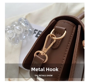 Detail of durable gold metal hook on vintage brown leather handbag with fine texture