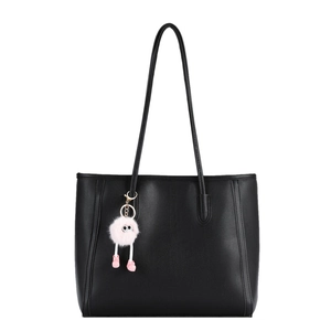 Minimalist black leather tote bag with a pink plush doll charm on white background