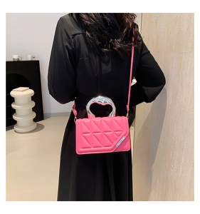 Detailed view of magenta quilted handbag with a wide silver metal circular handle