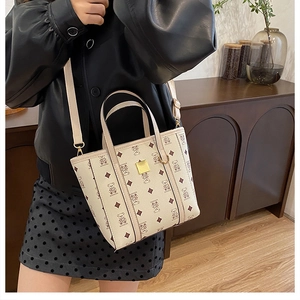 Détail du sac seau bandoulière crème avec monogramme d'ours vintage et dorures élégantes