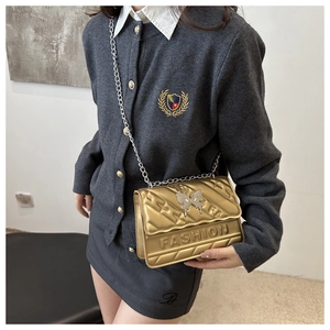 Sac bandoulière doré matelassé avec nœud métallique et lettrage embossé chic