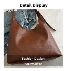 Detail of dark brown tote bag with vintage oil-waxed texture and adjustable gold buckle