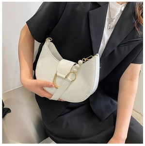 Detail of white crocodile pattern shoulder bag with gold ring and pearl chain
