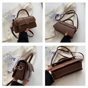 Detail view of a retro dark brown leather satchel with gold hardware and accordion sides