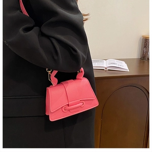Close-up of pink pebble leather handbag with leather buckle and gold hardware