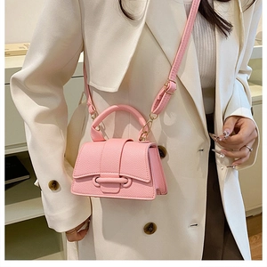 Detail of pink lychee leather mini handbag with gold hardware and adjustable strap