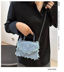Light blue denim handbag with frayed edges and silver chain strap shown as a crossbody bag