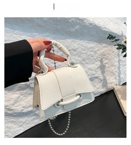 Détail du sac blanc en cuir grainé avec bandoulière chaîne à billes argentées