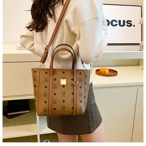 Détail d'un sac cabas marron à monogramme avec boucle dorée et bandoulière réglable