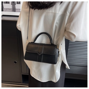 Detail of vintage black crossbody bag with white contrast stitching and V-shaped flap