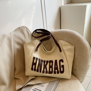 Chic cream white leather tote bag with brown straps and large HNKBAG lettering