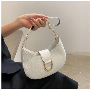 Detail view of white crocodile pattern hobo bag with gold buckle and pearl strap decor