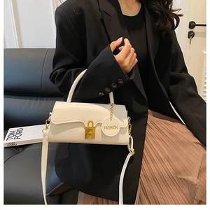 White leather shoulder bag with gold metal clasp and Fashion tag on model's hand