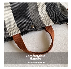 Detail of striped woven tote bag featuring reinforced brown handles and silver metal snap button