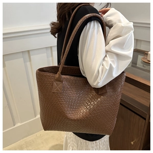 Brown woven tote bag side view on shoulder with minimalist checkered texture design