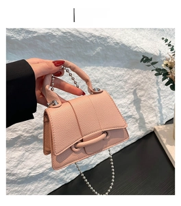 Détail du mini sac rose en cuir grainé avec chaîne à billes argentée et poignée en métal