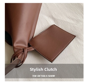 Detail view of dark brown leather tote with matching zipper pouch and fine stitching