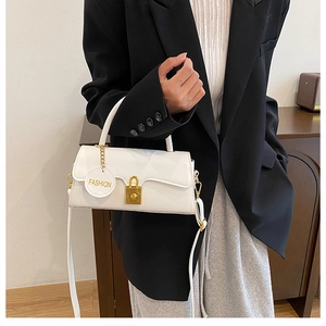 Close-up of a white vintage crossbody bag with a golden metal buckle and leather tag