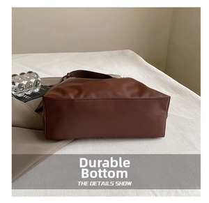 Close-up of the wear-resistant rectangular bottom of this brown leather tote bag