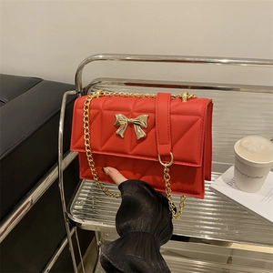 Borsa a tracolla trapuntata rossa con chiusura a fiocco dorato e catena metallica