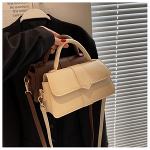 Detail shot of vintage small square bags in cream and dark brown with gold hardware