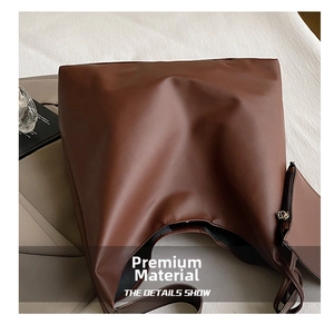 Detail of a dark brown large tote bag with matching coin purse and soft PU leather texture