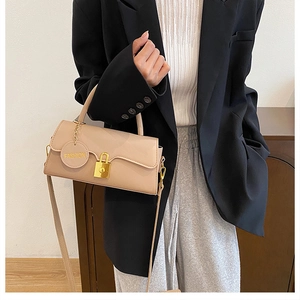 Close-up of a beige crossbody bag featuring a golden buckle and fashion brand tag