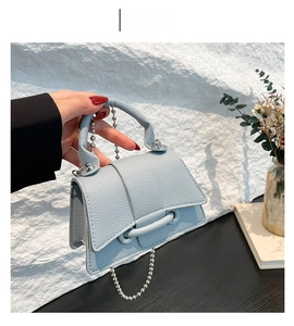 Détail du mini sac bleu clair motif litchi avec poignée en chaîne argentée pour femme