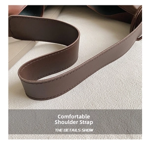Detailed close-up of brown leather shoulder strap with neat stitching and fine texture