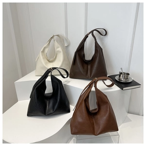 Detailed display of four vintage leather tote bags in cream, brown, black and caramel