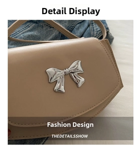Close-up of elegant silver bow buckle on apricot leather crossbody bag for women