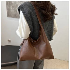 Side view of a dark brown minimalist tote bag with fine leather texture for daily commuting