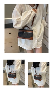 Detail view of denim and brown leather crossbody bag styled with casual white shirt