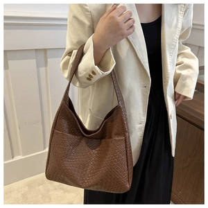Detailed close-up of brown woven texture and PU leather material on a large hobo bag
