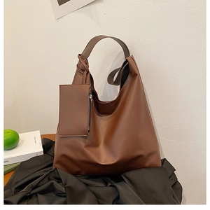 Detailed view of brown leather tote bag with a removable pouch and knot handle detail