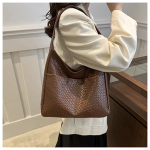 Detailed view of the dark brown woven texture and side pocket on this large tote bag