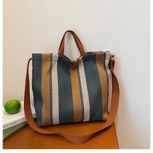 Vue détaillée du sac cabas en toile rayée avec bouton métallique et sangles en tissu