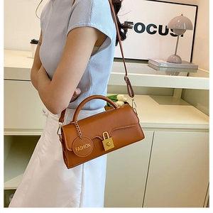 Detailed shot of brown vintage crossbody bag with gold hardware and fashion tag