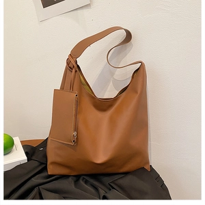 Detailed macro view of caramel tote bag showing matte texture and mini zipper pouch attachment