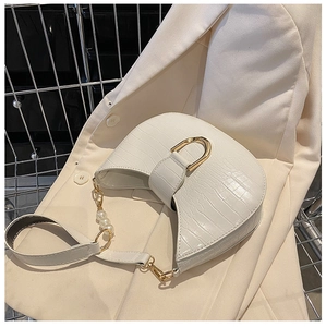 Detail of white crocodile pattern half-moon bag with elegant pearl chain and gold hardware