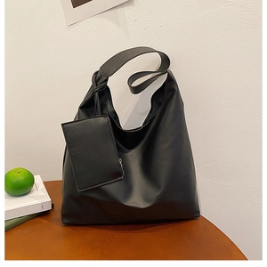 Minimalist black matte hobo bag with side knot detail and matching small zipper pouch