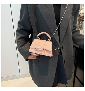 Détail du mini sac bandoulière rose motif litchi avec chaîne à billes argentée sur modèle