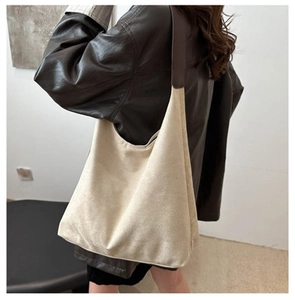 Gros plan détaillé sur la texture du grand sac cabas en toile beige avec bandoulière en cuir