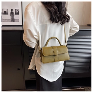 Olive green vintage crossbody bag styled with a white shirt and black skirt